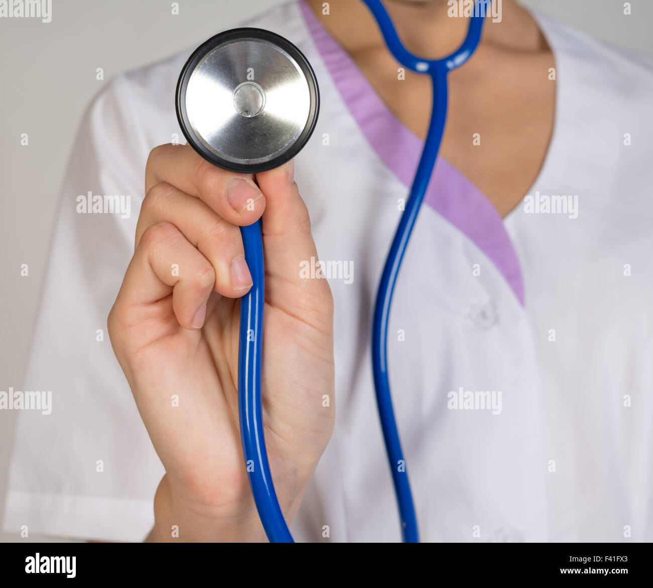 Femme médecin dans un lab coat holding a stethoscope Banque D'Images