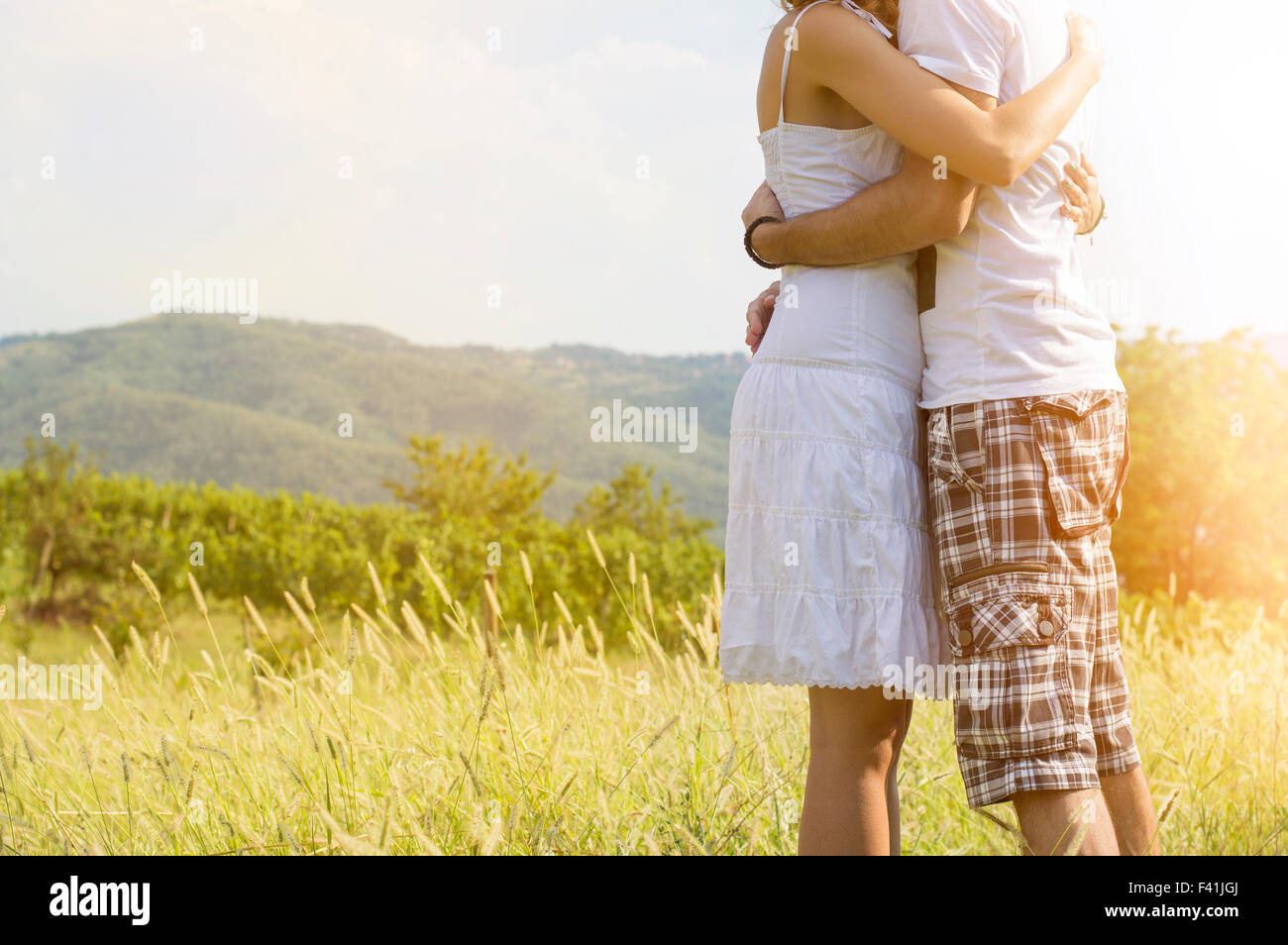 Loving couple hugging strong extérieur sans visages illustré. Sunburst romantique fuite de lumière Banque D'Images