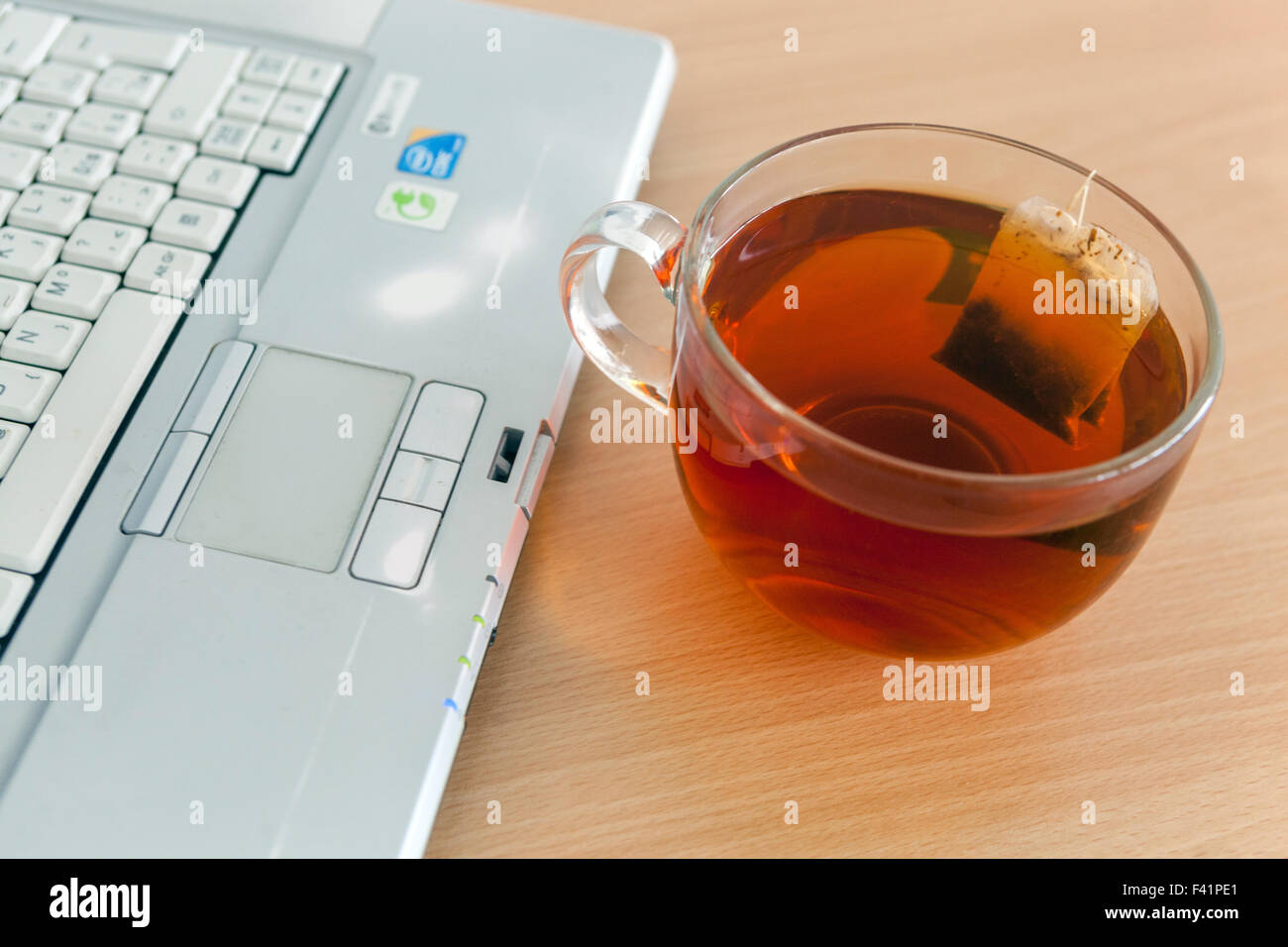 Une tasse de thé sur une table, ordinateur portable Banque D'Images