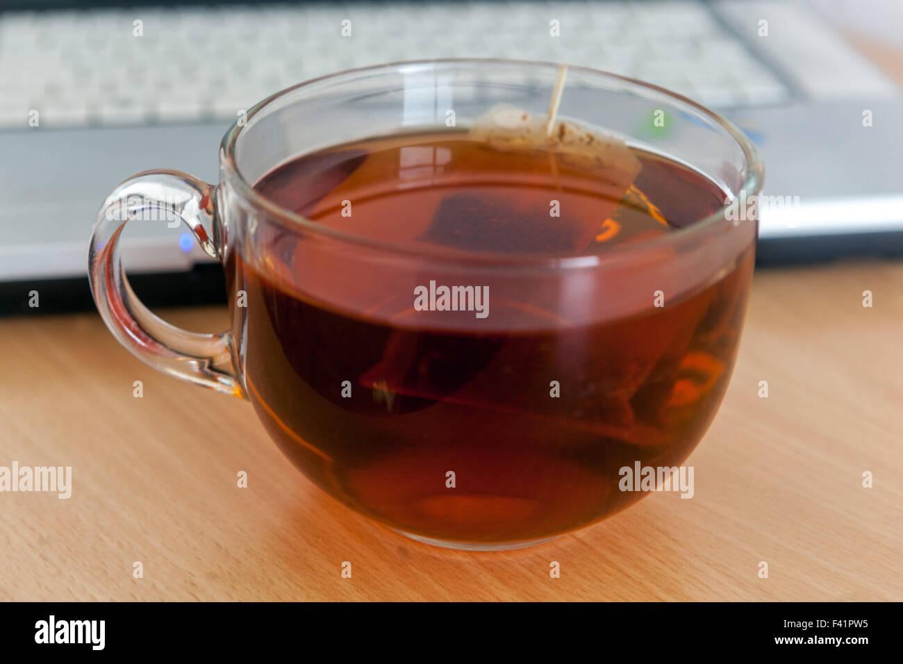 Une tasse de thé sur une table, ordinateur portable Banque D'Images