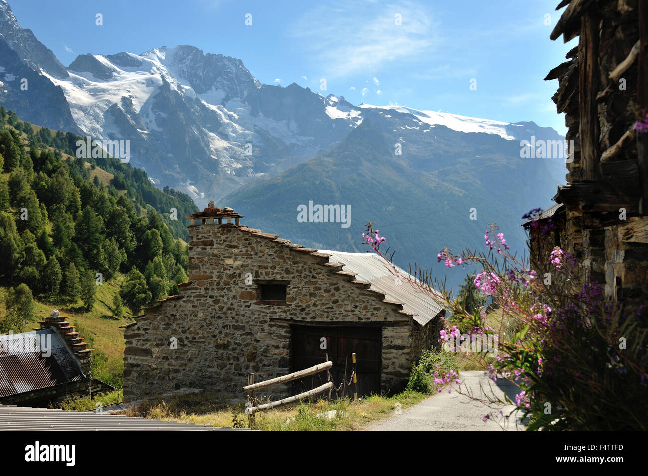 Maisons de pierre et de bois dans le petit hameau entouré par de magnifiques paysages de montagne dans la région de Valfroide, Alpes, France Banque D'Images