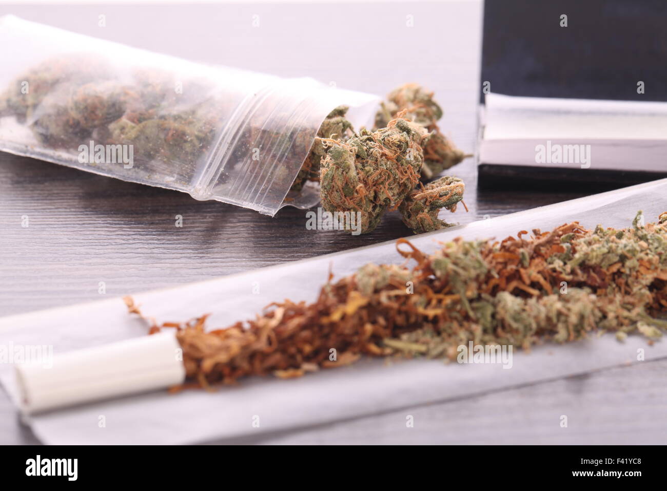 Close up cannabis séché feuilles sur un sac Cellophane et un papier à rouler avec filtre sur le dessus de la table Banque D'Images