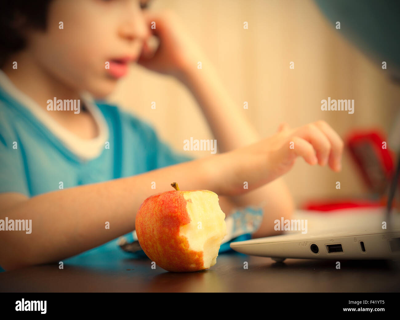 Mordu apple et un garçon avec l'ordinateur Banque D'Images