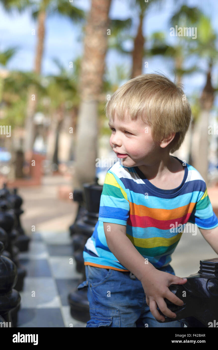 Enfant jouant avec un échiquier géant Banque D'Images