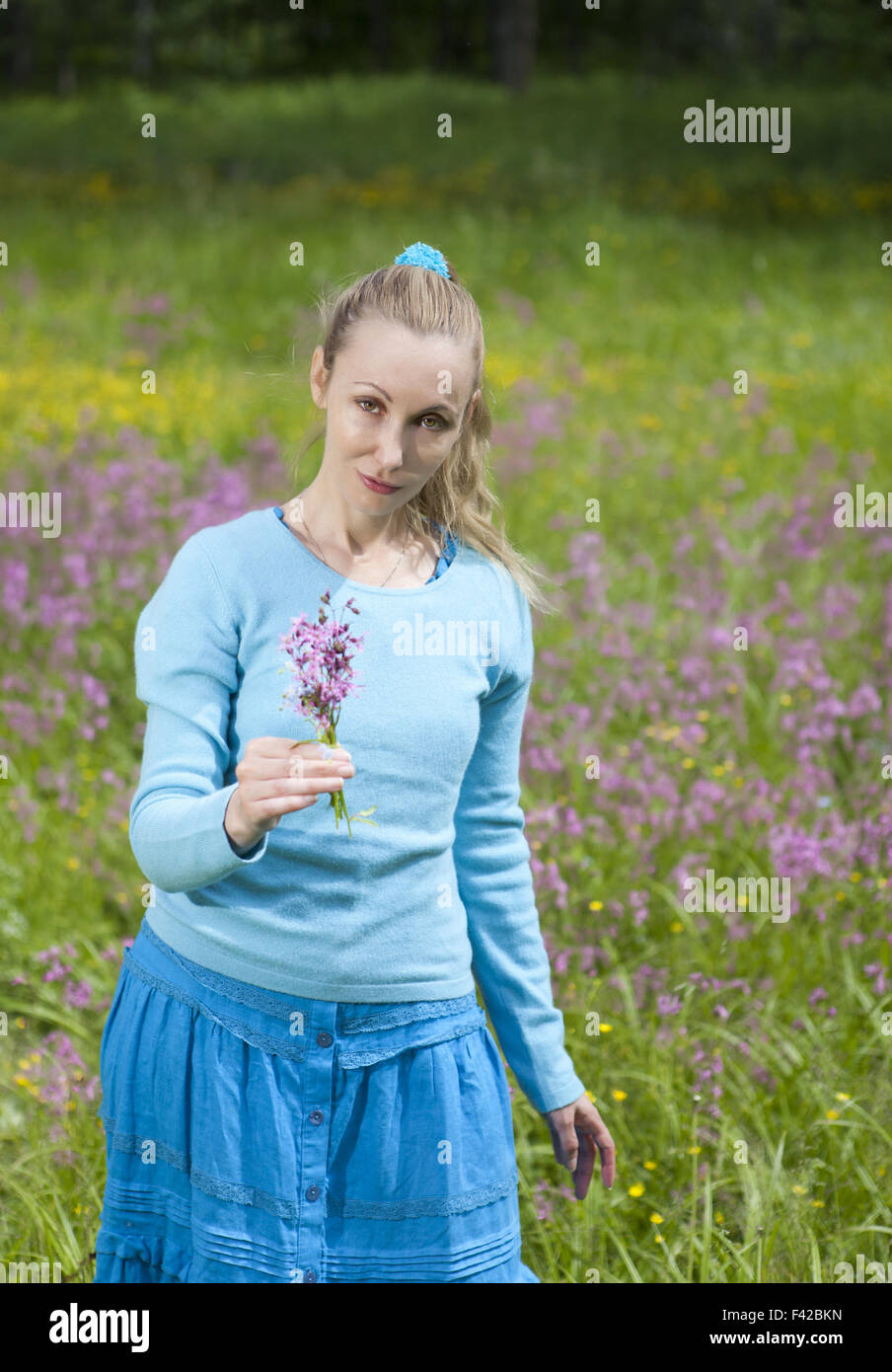 Jeune femme dans le champ de fleurs sauvages Banque D'Images