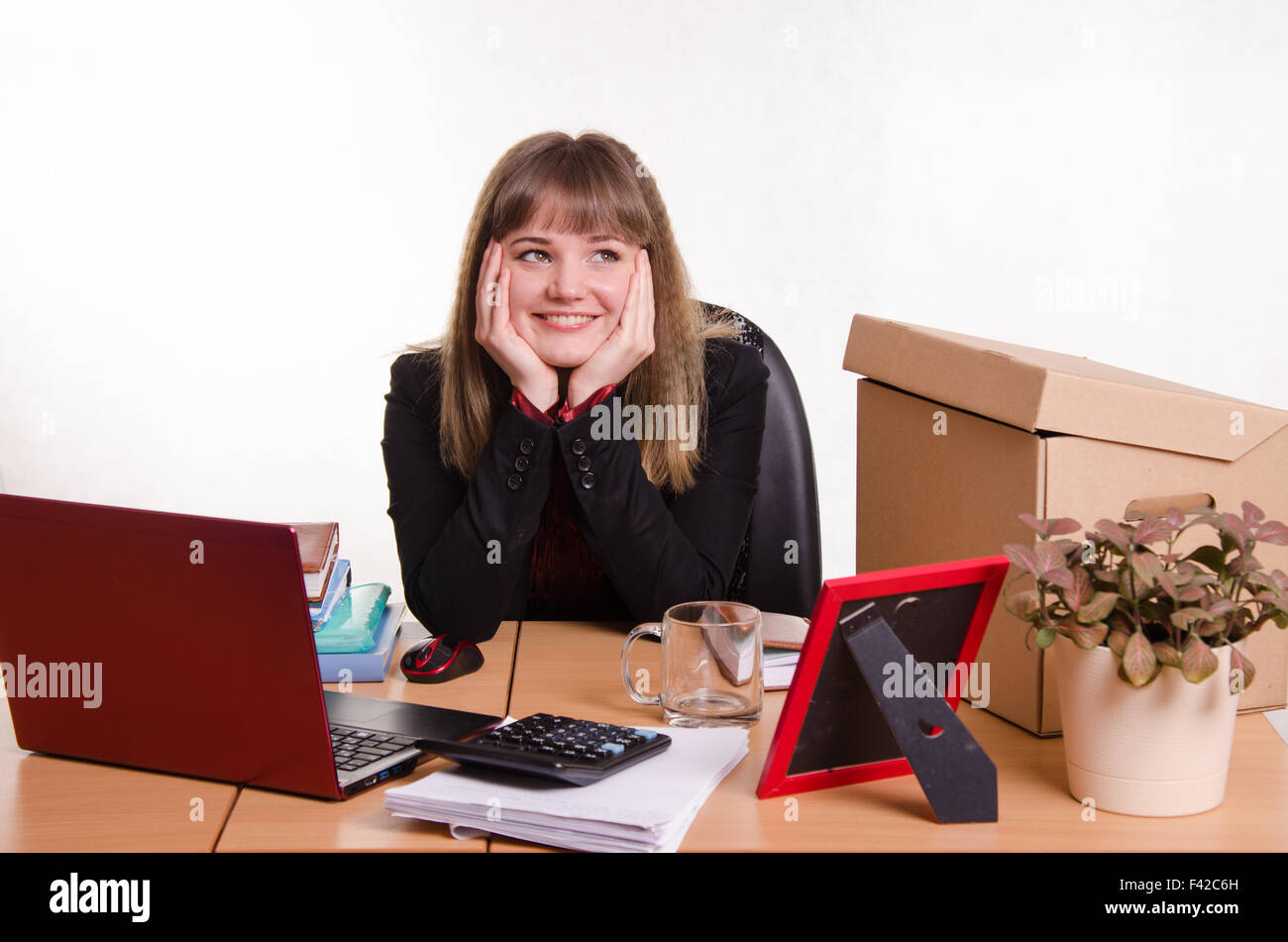 Femme assise à un bureau Banque D'Images