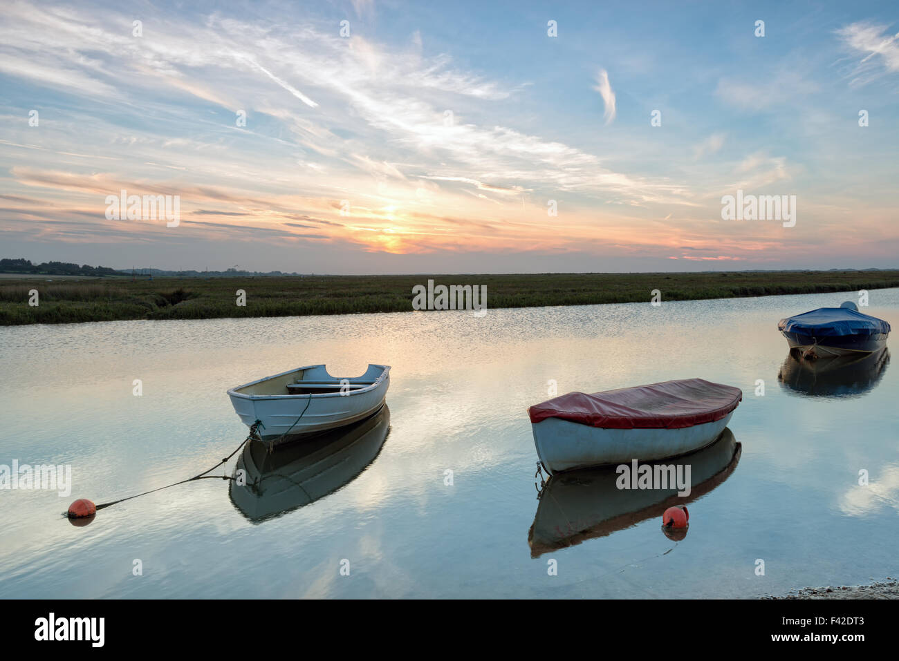 L'Aviron bateaux amarrés sur le fleuve à Blakeney sur la côte de Norfolk Banque D'Images