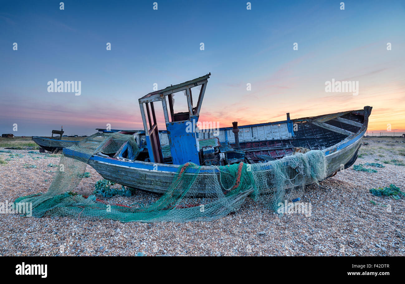 Les bateaux de pêche sous un ciel dramatique crépuscule sur bardeau à Dungeness sur la côte du Kent Banque D'Images