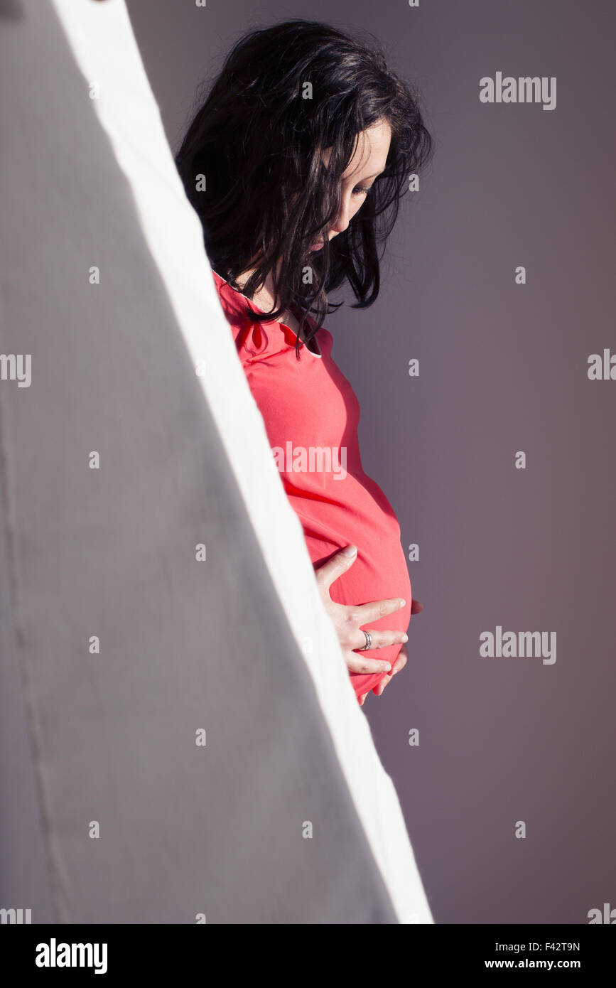 Pregnant woman holding estomac, regardant vers le bas Banque D'Images