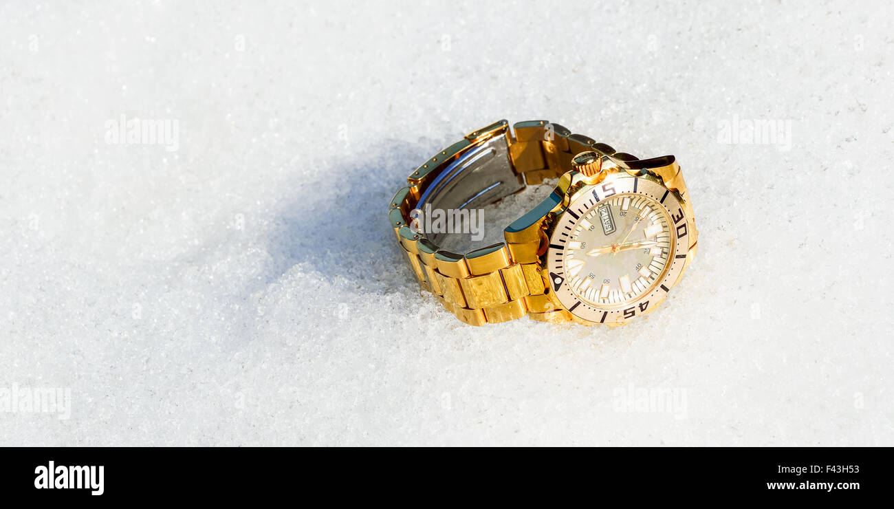 Horloge dorée dans la neige Banque D'Images
