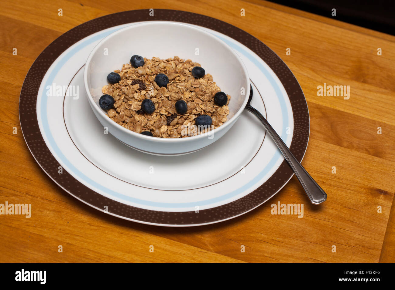Le petit-déjeuner avec les bleuets, granola dans un bol qui est assis sur une table en bois. Banque D'Images