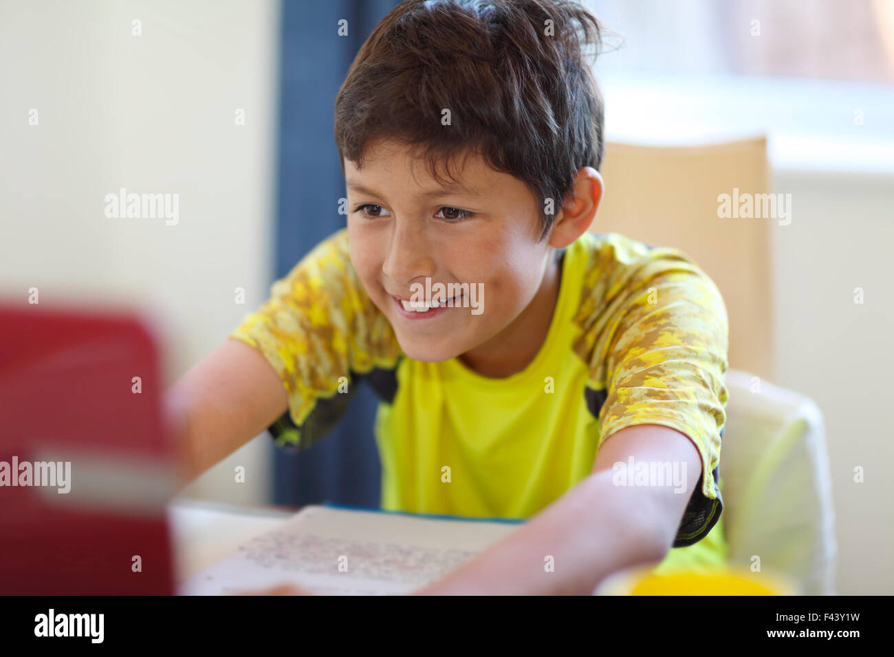 Jeune garçon fait ses devoirs sur un ordinateur - faible profondeur de champ Banque D'Images
