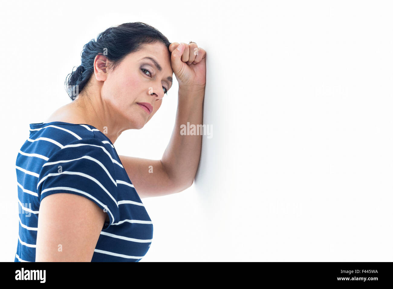 Femme triste appuyé contre le mur Banque D'Images