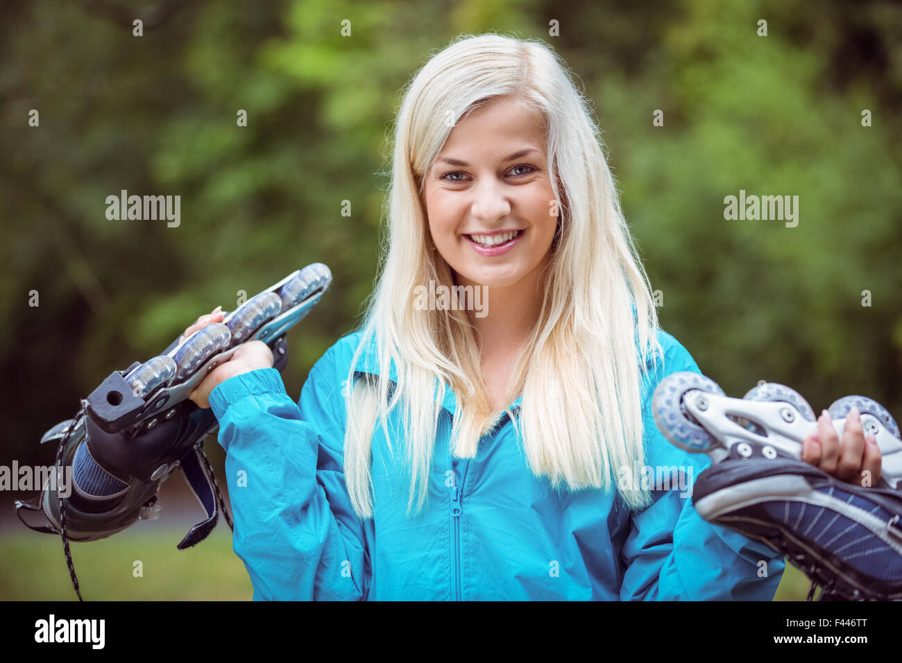 Happy blonde holding patins Banque D'Images