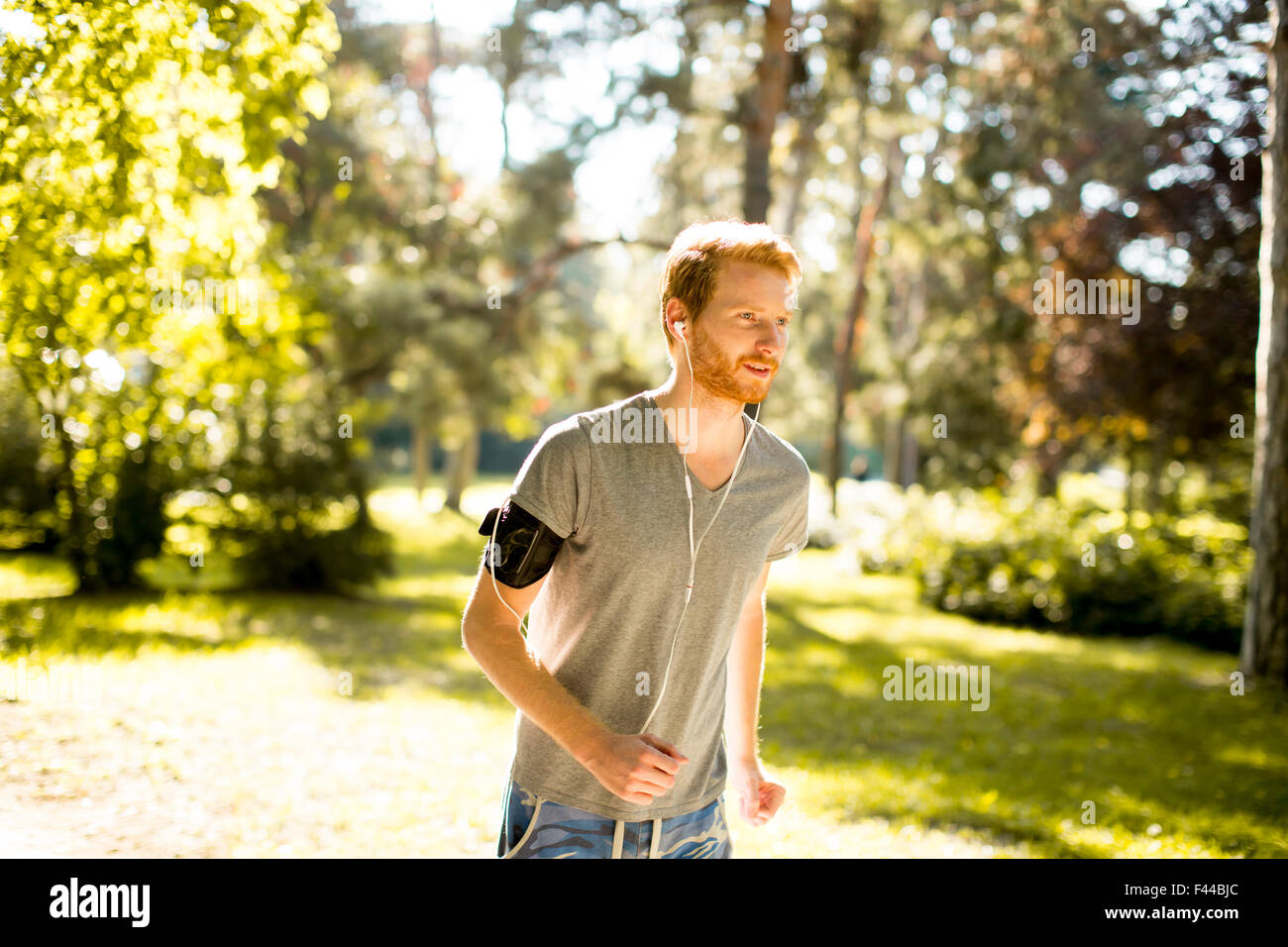Jeune homme d'exécution dans le parc en automne Banque D'Images