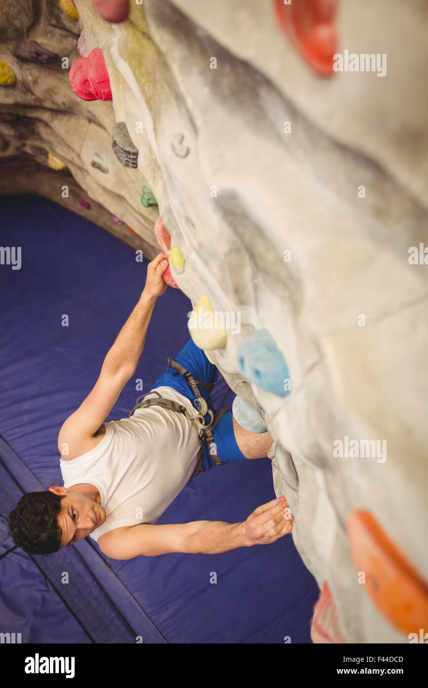 Man climbing up rock wall Banque D'Images