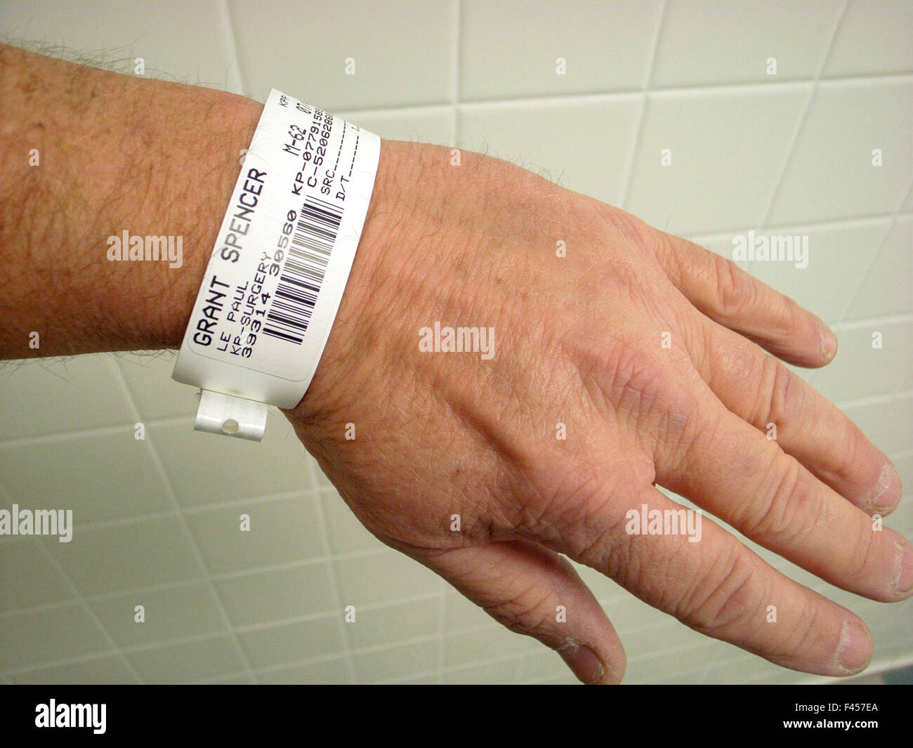 Un hôpital patient porte un bracelet d'identification temporaire avec un code barre et d'autres données personnelles. Banque D'Images