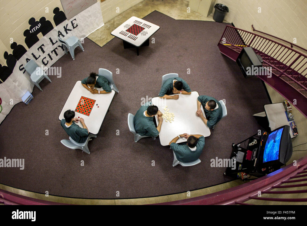 Les détenus Hispanic teenage en uniforme d'une Orange, CA, prison pour mineurs jouer jeux de table dans leur chambre. Banque D'Images