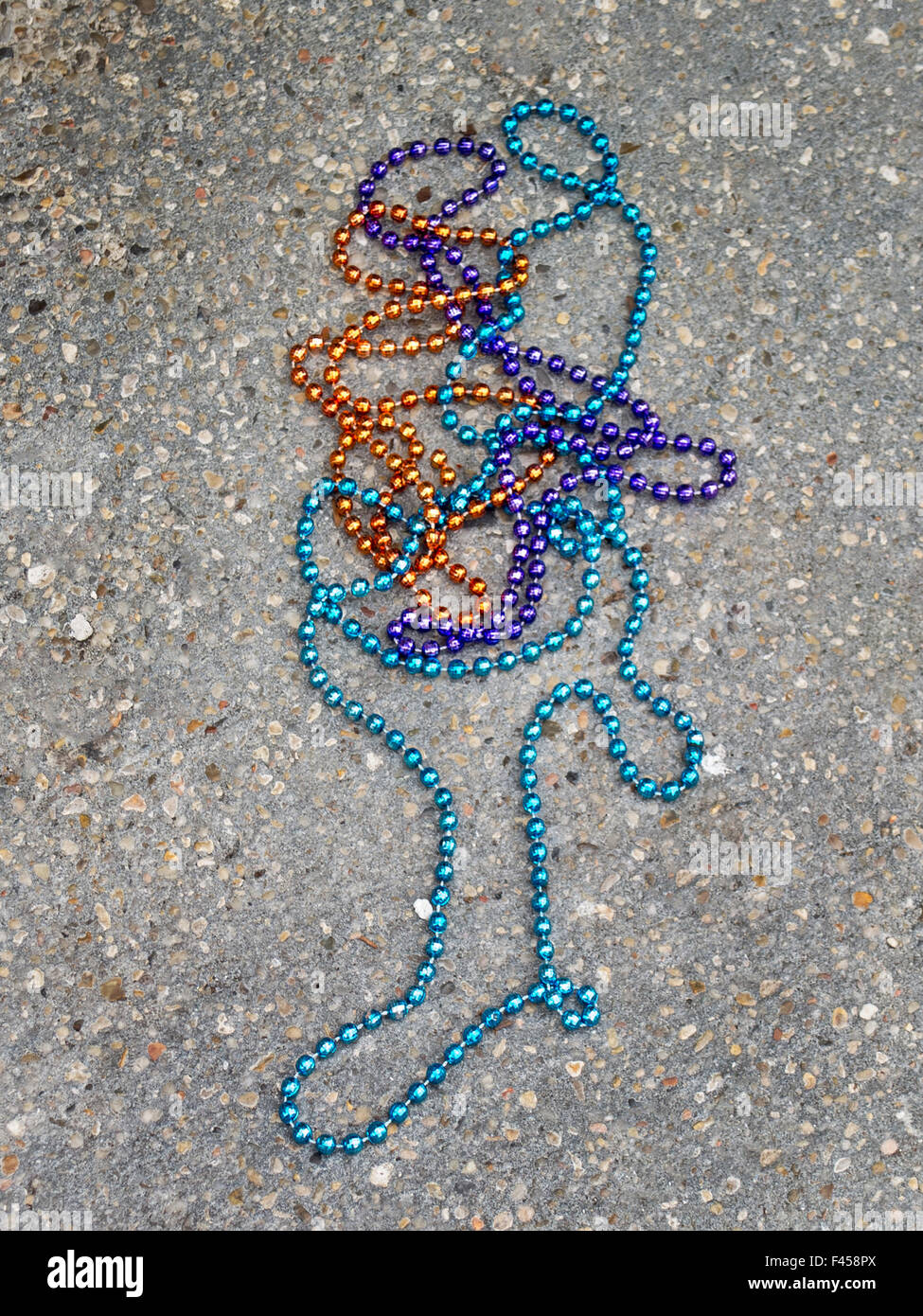 Un Mardi Gras collier de perles de verre de couleur se trouve sur un  trottoir de La Nouvelle-Orléans. Les colliers sont souvent un signe dans la  ville Photo Stock - Alamy