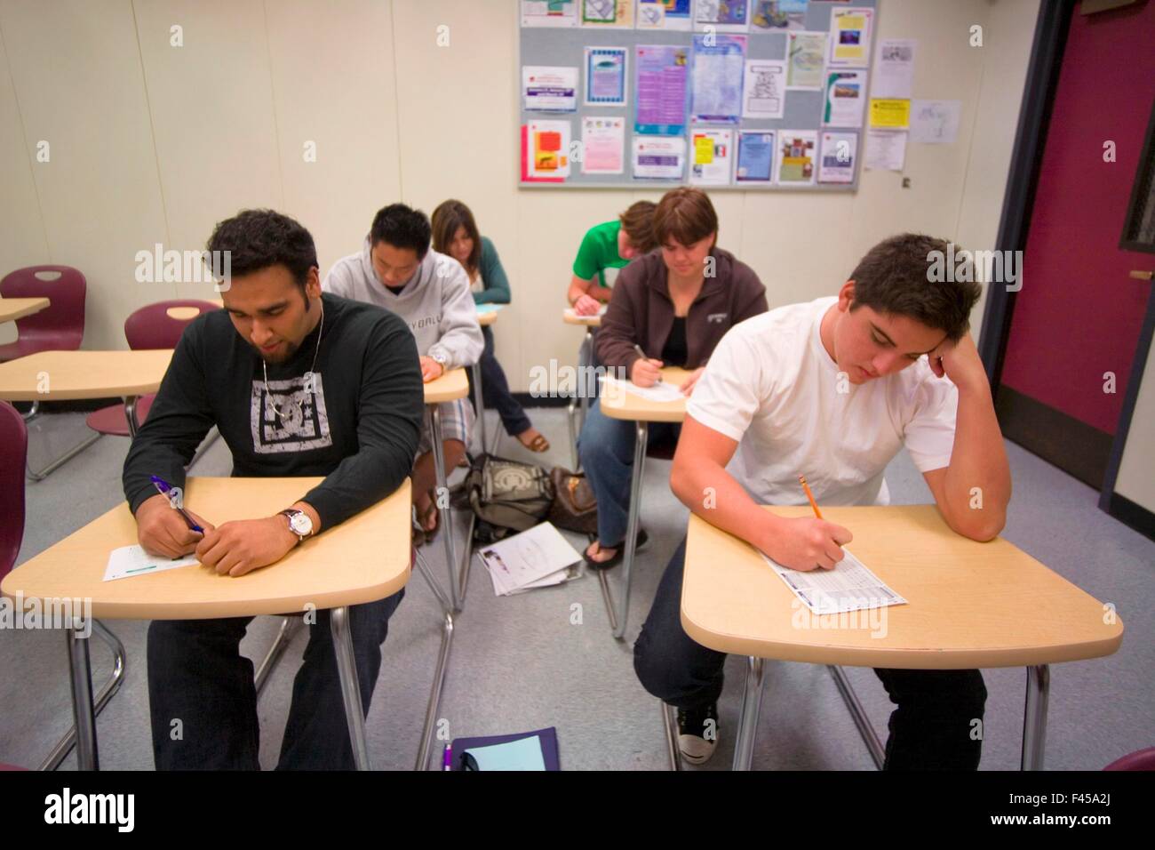 En utilisant un crayon à compléter les feuilles Scantron multiraciale Californie du Sud, les étudiants des collèges communautaires de prendre un test standardisé sur papier lisible par machine de marquage formulaires réponses aux questions du test à choix multiples. L'imagerie et la reconnaissance optique de marques scanners sont Banque D'Images