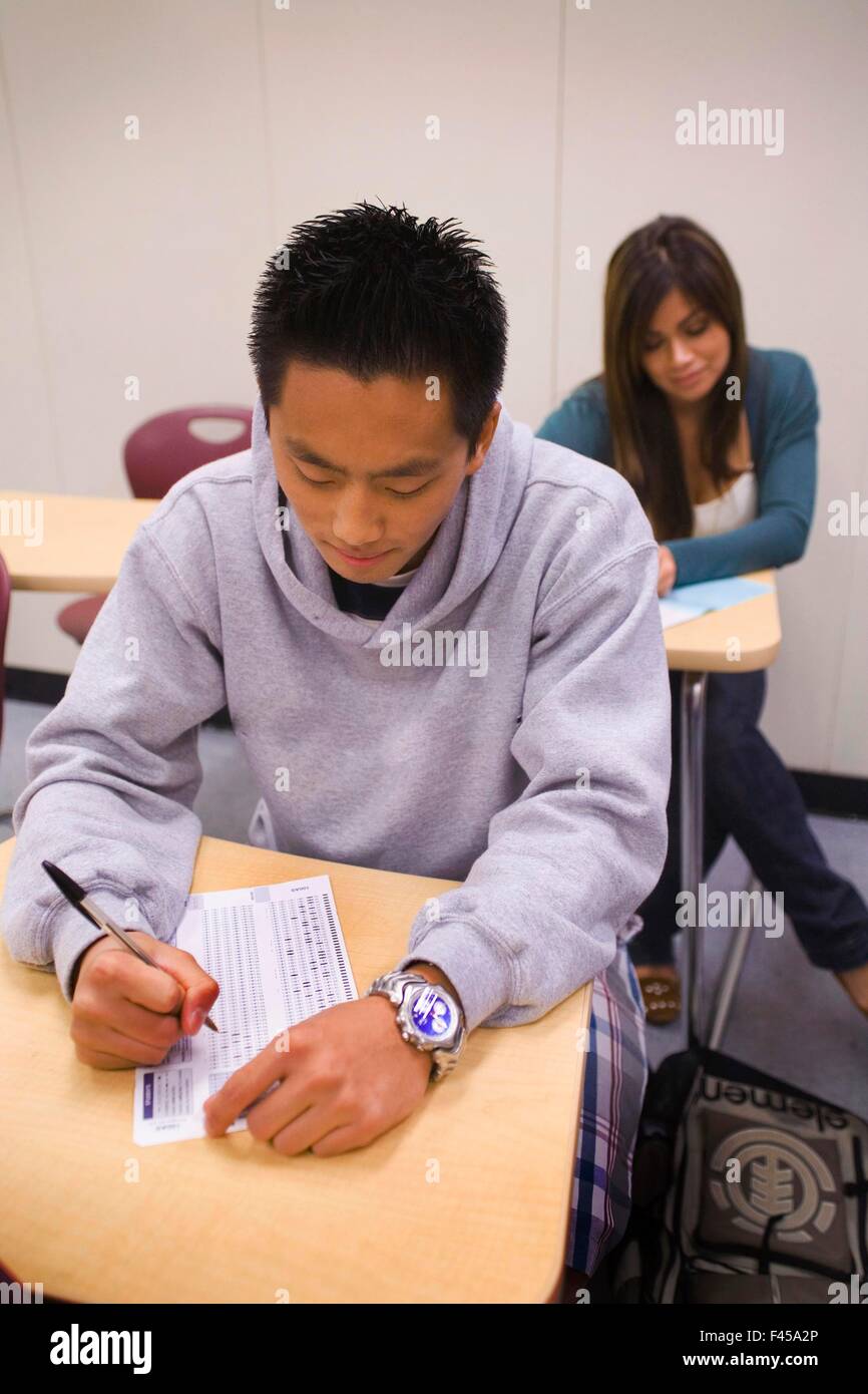 En utilisant un crayon à compléter les feuilles Scantron multiraciale Californie du Sud, les étudiants des collèges communautaires de prendre un test standardisé sur papier lisible par machine de marquage formulaires réponses aux questions du test à choix multiples. L'imagerie et la reconnaissance optique de marques scanners sont Banque D'Images