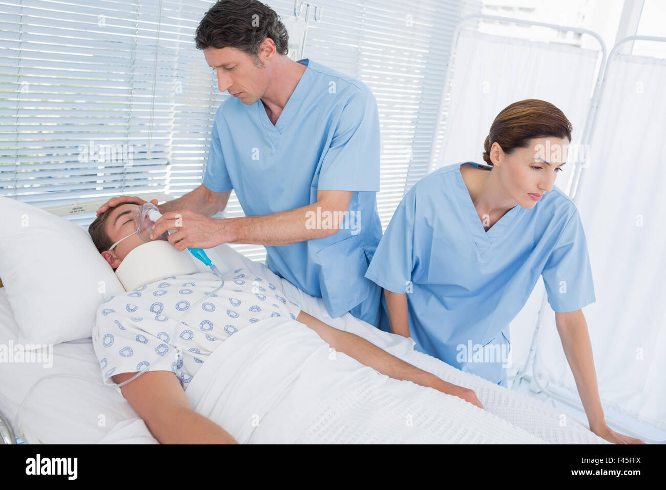 Doctors holding patients masque à oxygène Banque D'Images