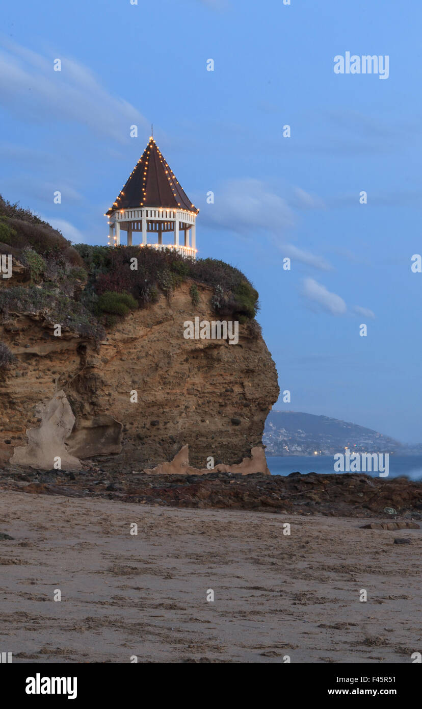 Coucher de soleil sur le gazebo dans Laguna Beach comme l'eau coule sur la plage Banque D'Images