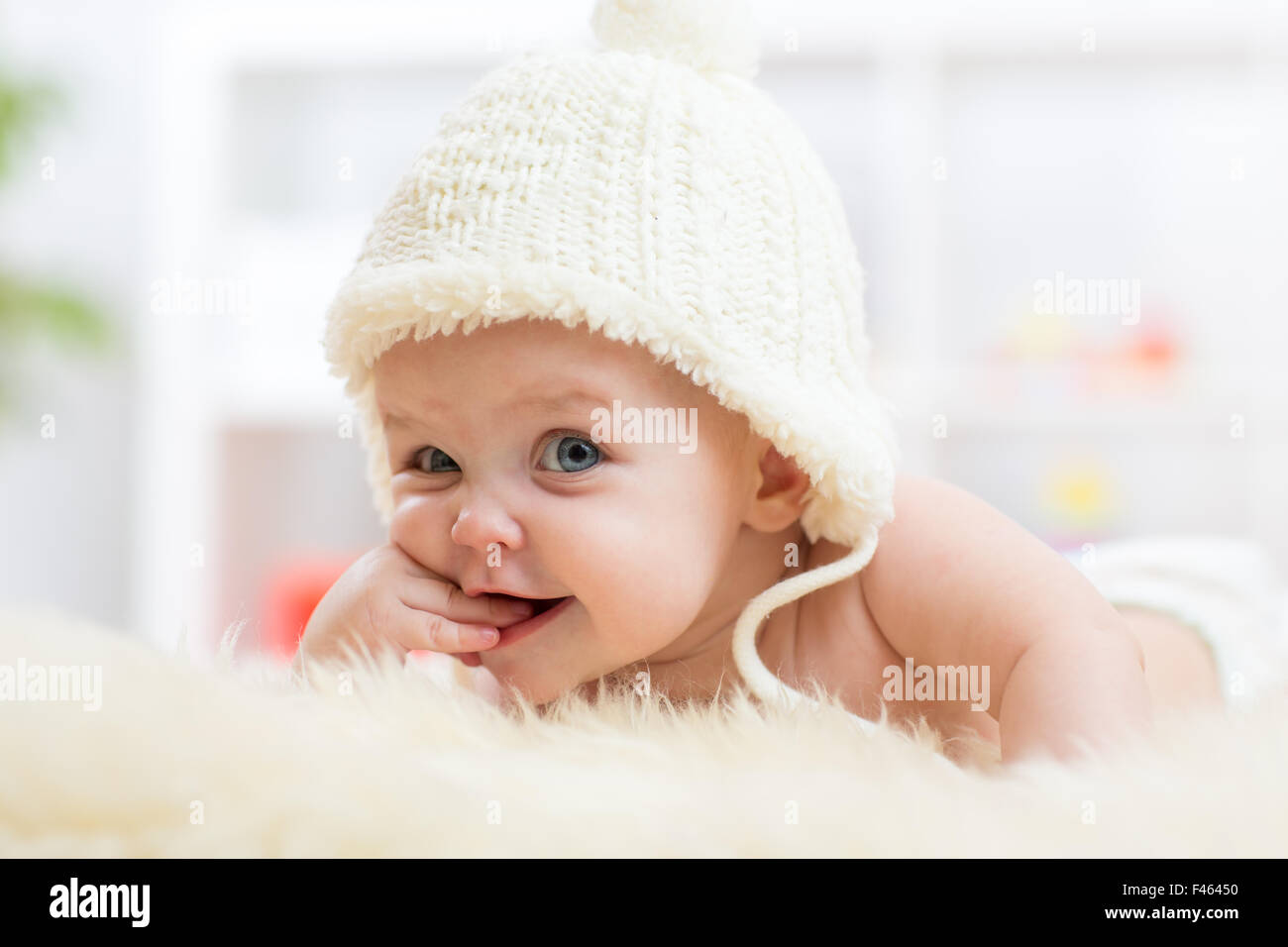 Cute little baby à la recherche dans l'appareil photo et portée en white hat. Banque D'Images