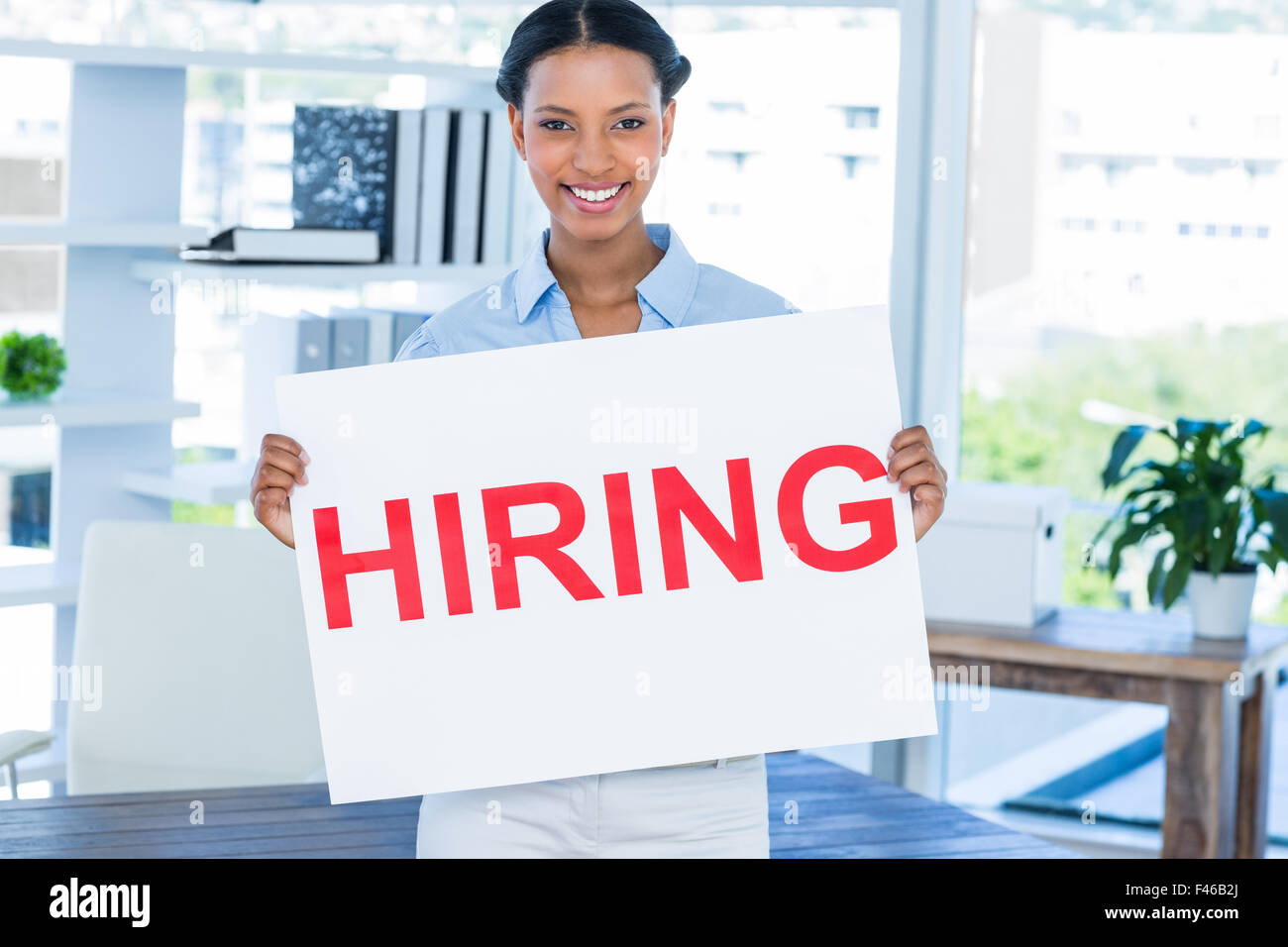 Happy businesswoman holding blank paper Banque D'Images