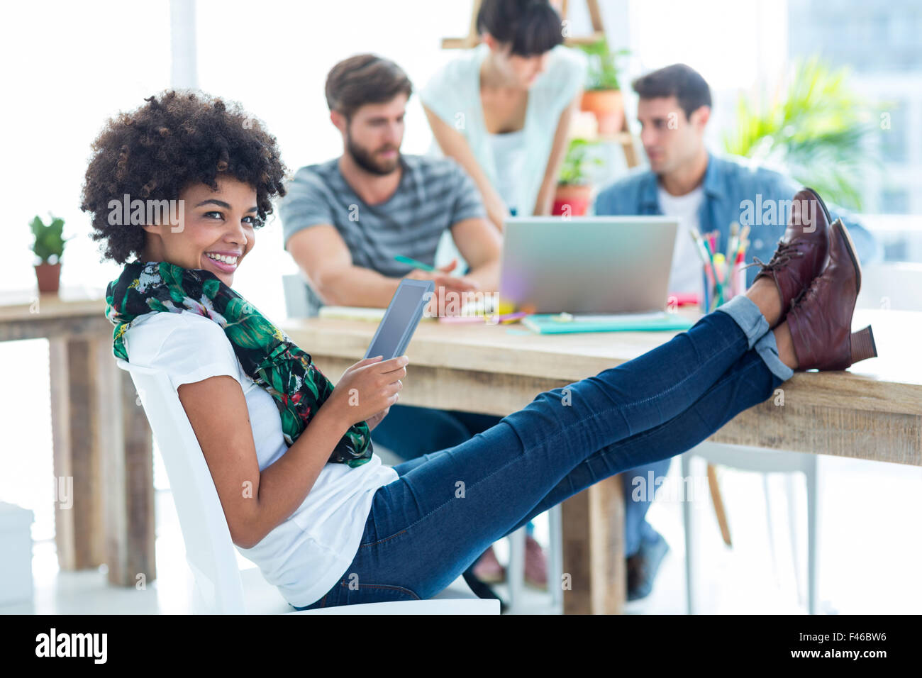 Jeune femme avec les pieds sur la table Banque D'Images