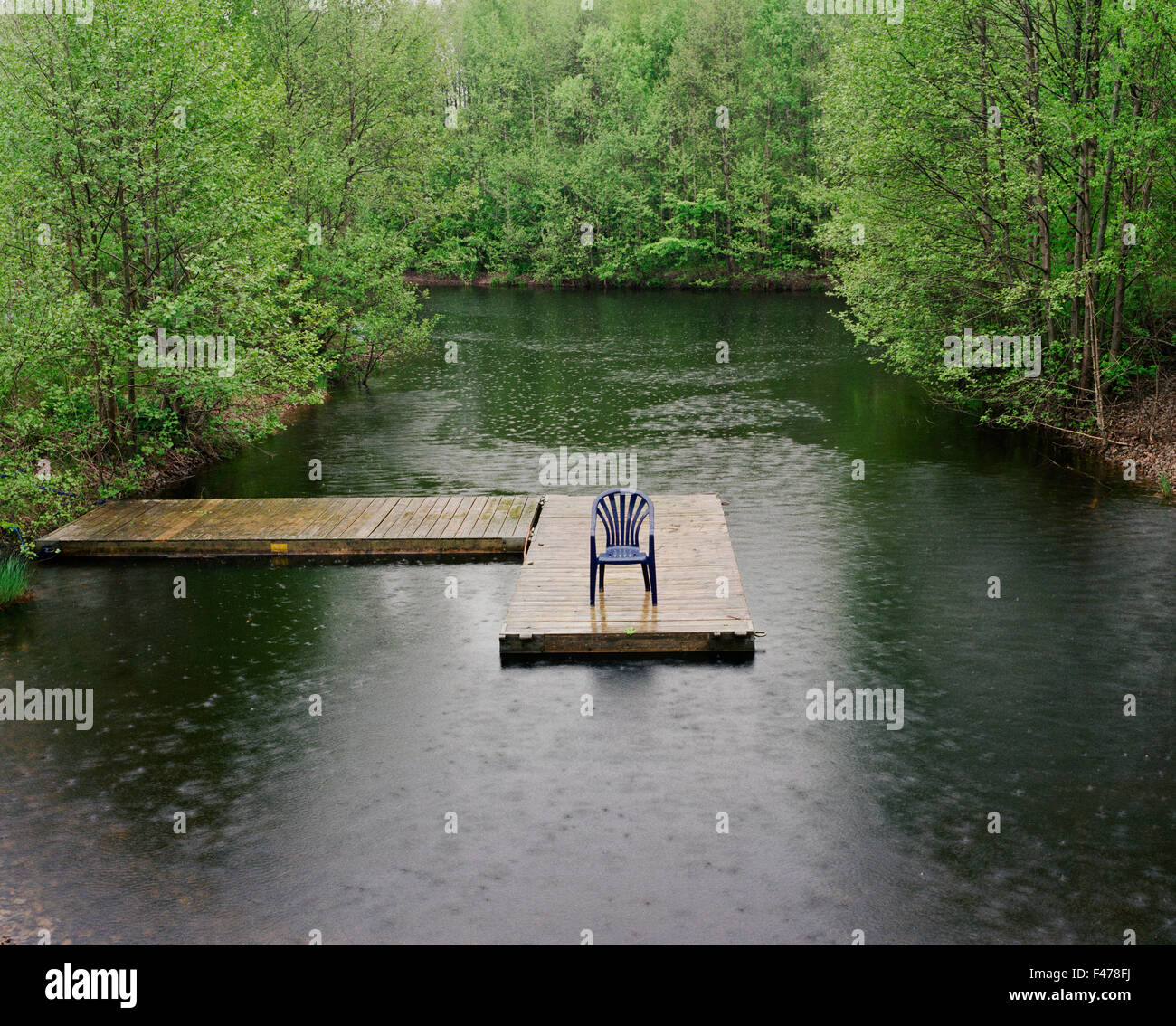 Une chaise sur une jetée dans une petite rivière, la Suède. Banque D'Images