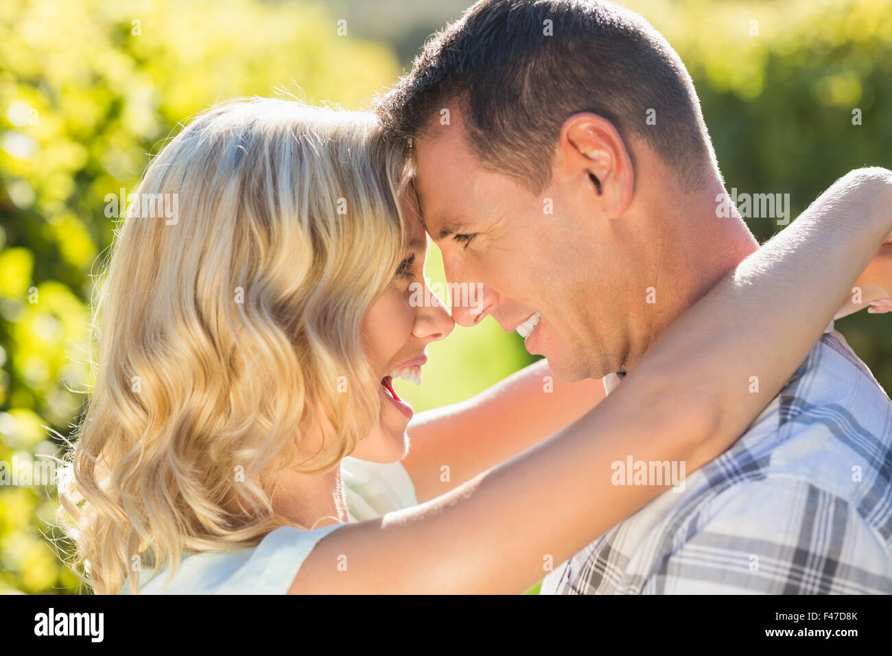 Smiling couple embracing et regardaient intensivement à côté de grapevine Banque D'Images Smiling couple embracing et regardaient intensivement à côté de grapevine Banque D'Images