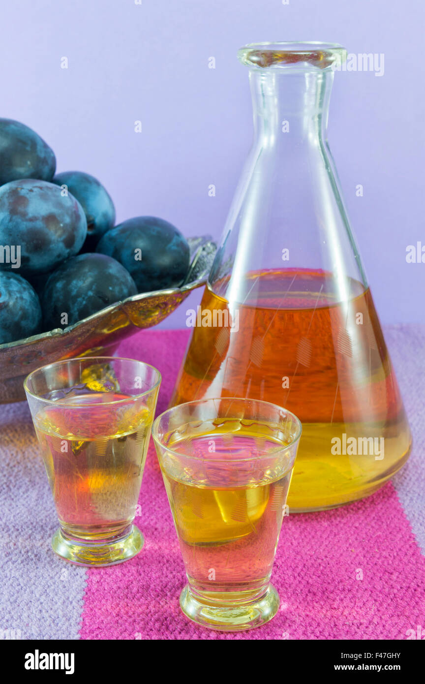L'eau de vie de prune et de prunes fraîches servi sur la nappe Banque D'Images