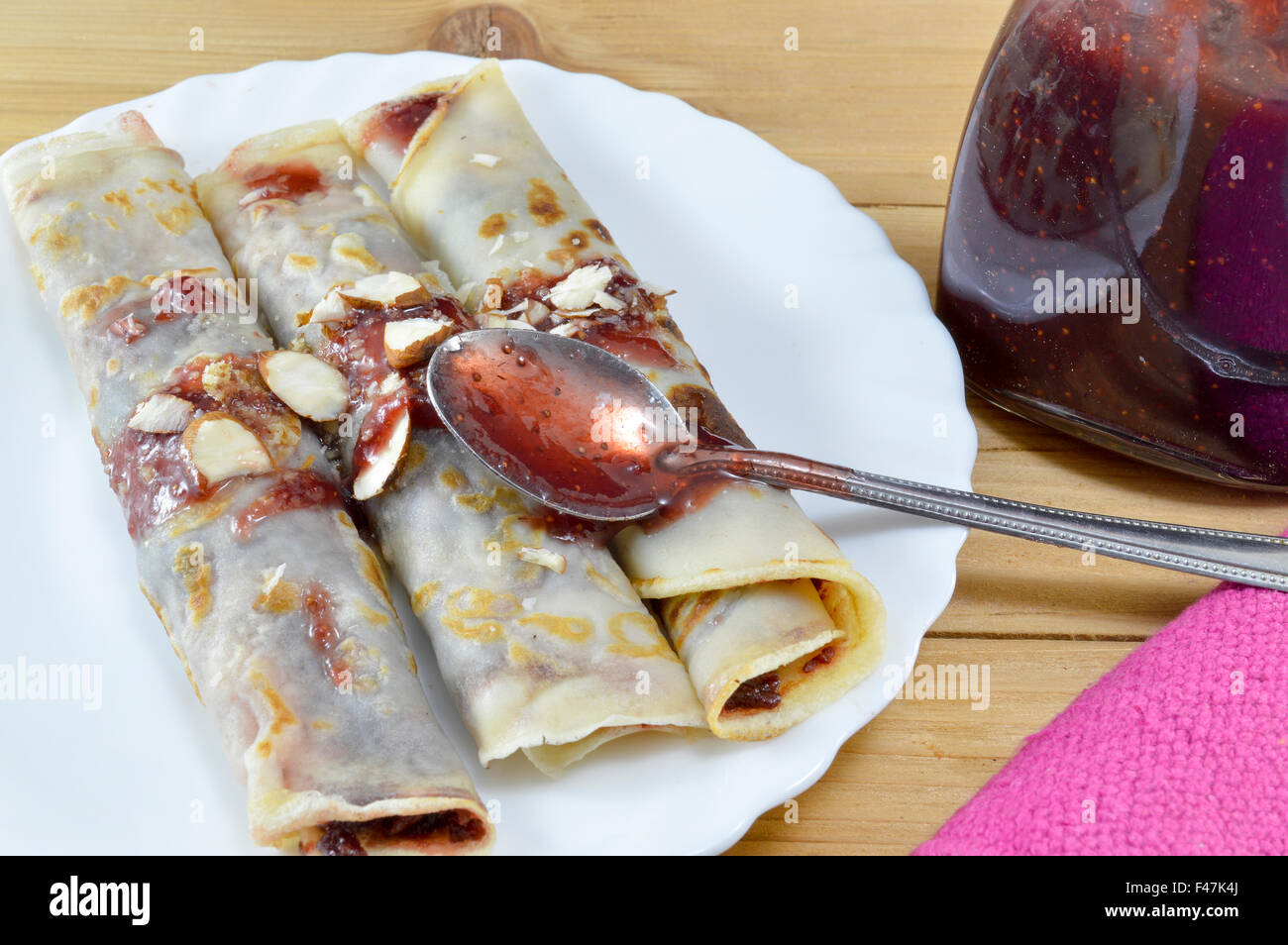 Crêpes sucrées avec de la confiture de fraise et de noisettes servi sur la plaque Banque D'Images