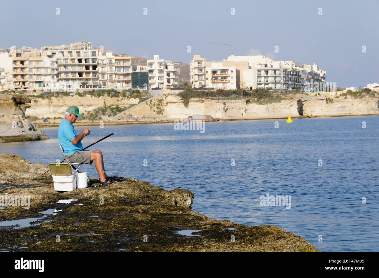 Pêcheur en face de Marsalforn, Marsalforn, Gozo, Malte, Europe du Sud, Mer Méditerranée Banque D'Images