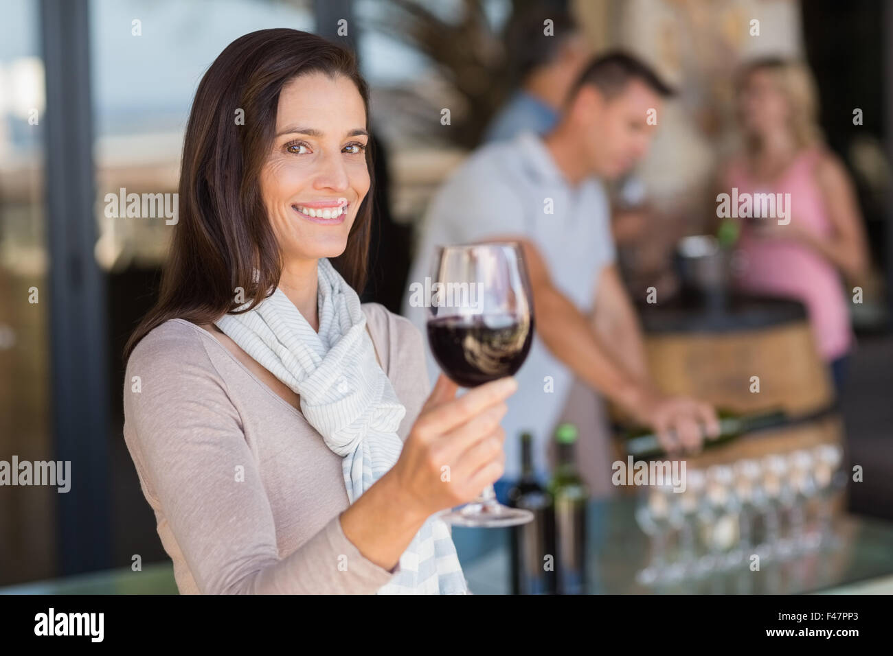 Portrait of smiling woman with wineglass en face de sommelier et couple drinking wine Banque D'Images Portrait of smiling woman with wineglass en face de sommelier et couple drinking wine Banque D'Images