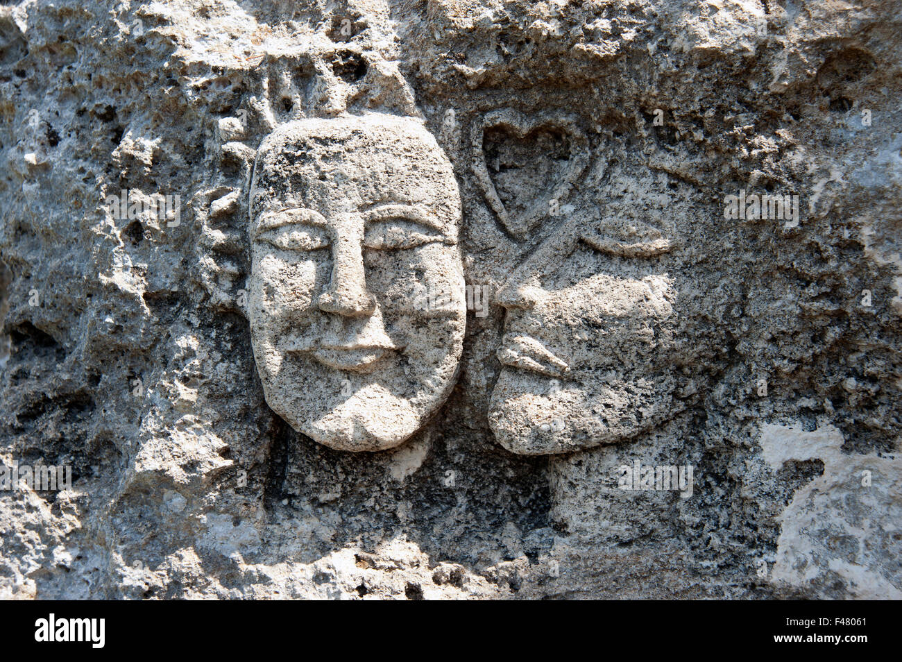 Deux amoureux visages sculptés dans la falaise au-dessus de criques Calas sur l'île de Minorque espagne Banque D'Images