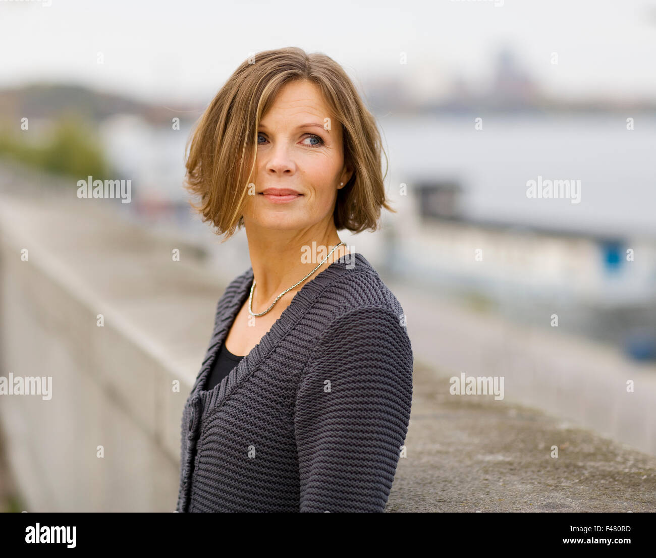 Portrait d'une femme appuyée contre un mur de pierre, la Suède. Banque D'Images Portrait d'une femme appuyée contre un mur de pierre, la Suède. Banque D'Images