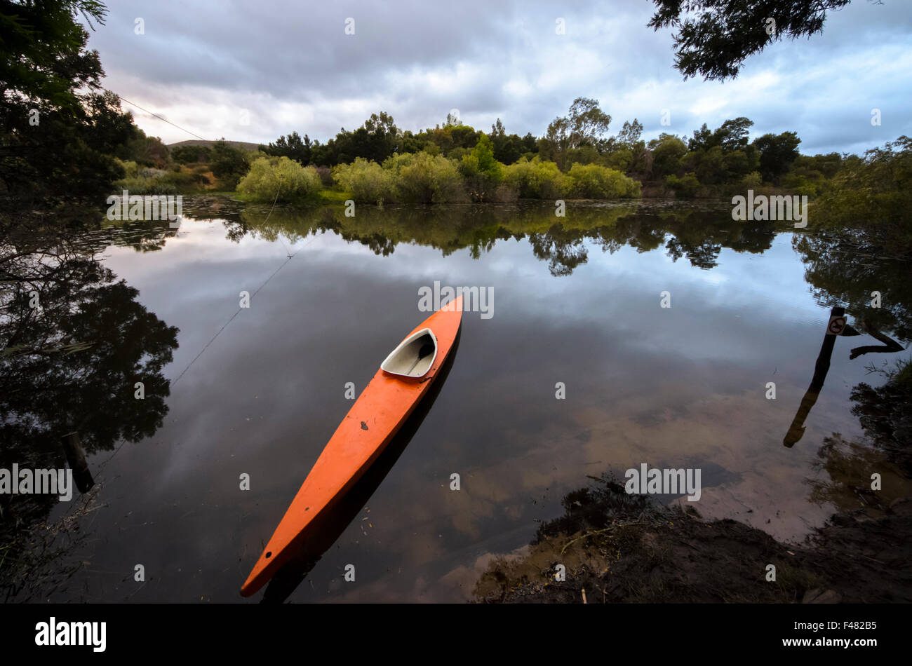 Tôt le matin, paisible Scène de rivière avec une orange, canoë dans la rivière Breede, Western Cape, Afrique du Sud. Banque D'Images