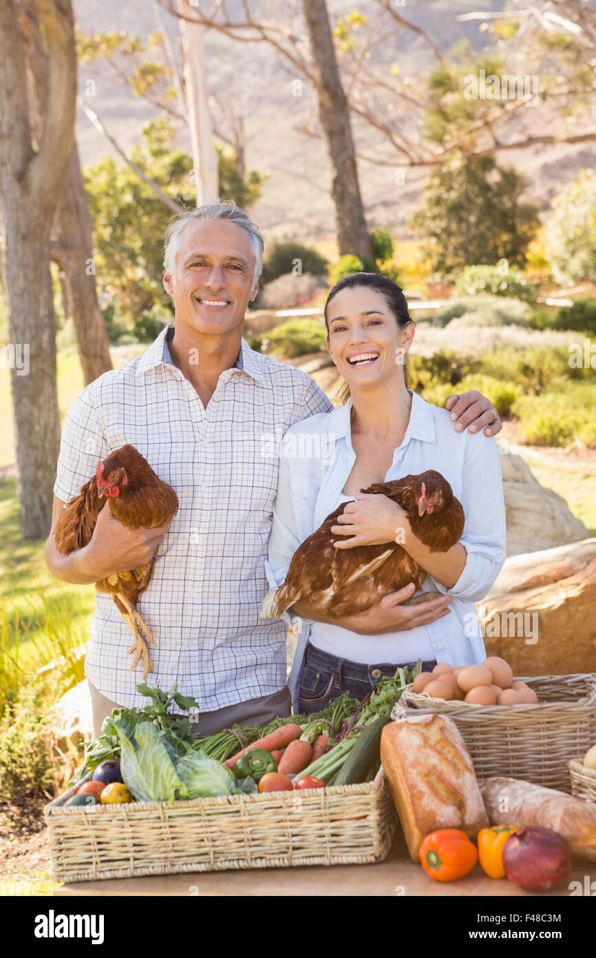 Farmer Smiling couple holding le poulet et les œufs Banque D'Images Farmer Smiling couple holding le poulet et les œufs Banque D'Images