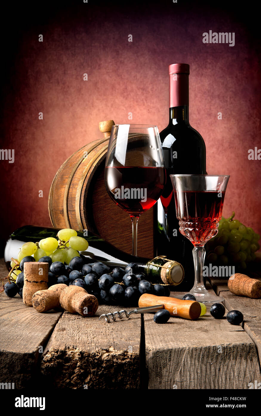Vin rouge au raisin et tonnelet en bois sur une table en bois Banque D'Images