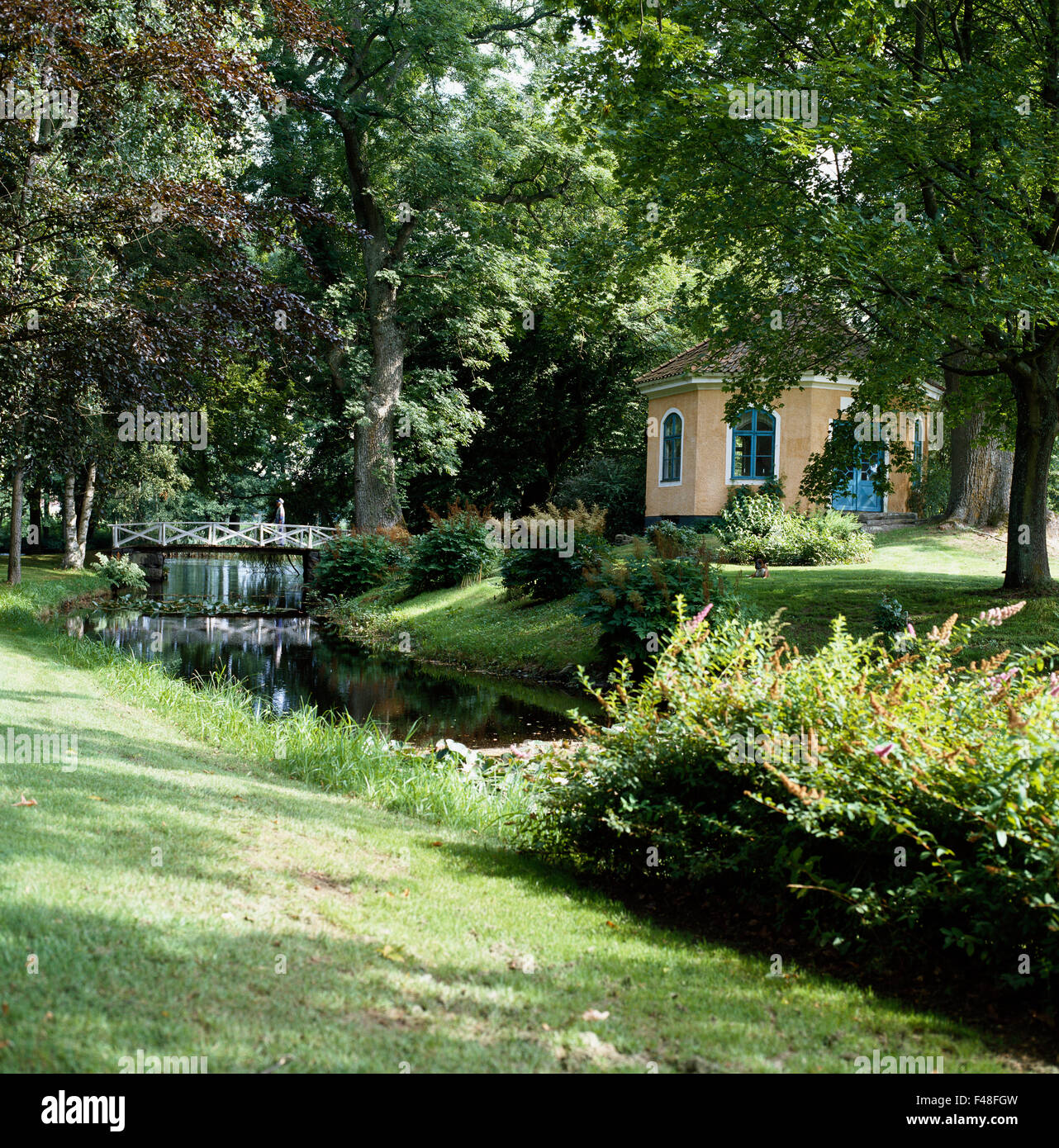 Un ruisseau et un pavillon de jardin dans un jardin, Smaland, Suède. Banque D'Images