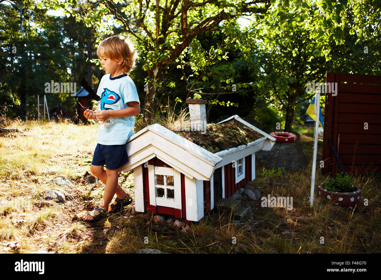 Garçon par une maison miniature, en Suède. Banque D'Images
