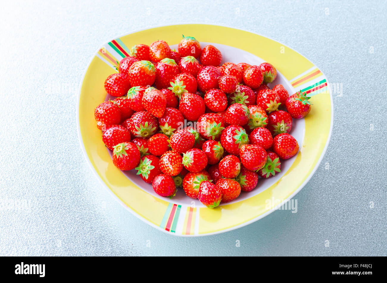 Plaque blanche jaune avec des fraises Banque D'Images