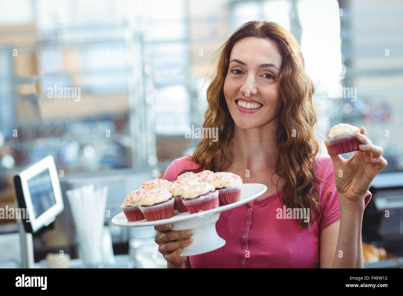 Belle brune montrant cupcake Banque D'Images