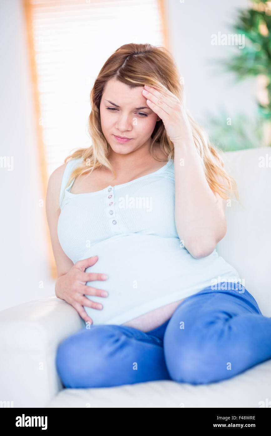 Femme enceinte ayant des maux de tête sur la table Banque D'Images