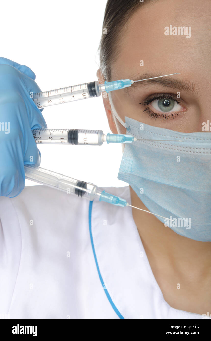 Portrait du docteur dans un masque avec des seringues Banque D'Images