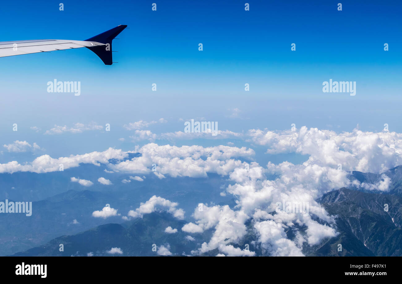 Aile d'un avion volant au-dessus de nuages sur les montagnes de l'himalaya Banque D'Images