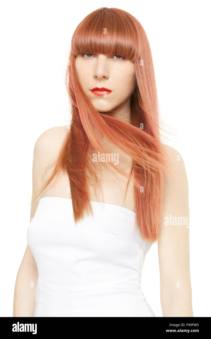 Les cheveux rouges. Jeune femme avec de longs cheveux raides, dans le vent avec fringe on white Banque D'Images