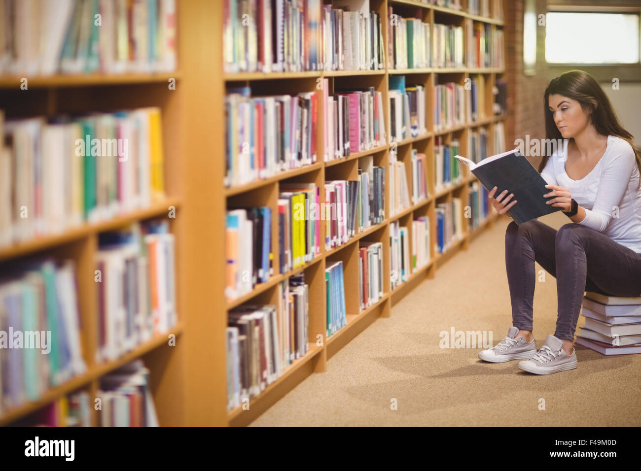 Belle étudiante assis lors de la lecture de note Banque D'Images